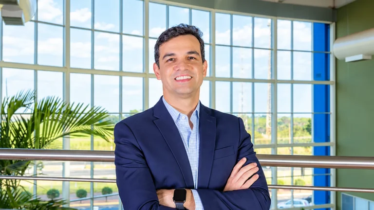 Kleber Gomes, CEO da Ourofino Saúde Animal, em retrato corporativo de braços cruzados, vestindo terno azul-marinho.